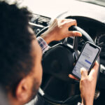 Man driving while texting on his phone