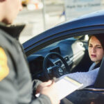 Policeman issuing a speeding ticket to a driver