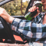 Young man driving while drinking